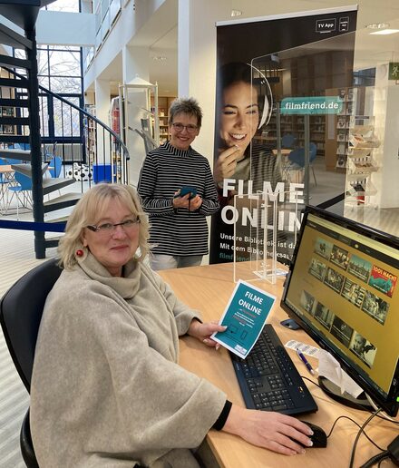 Spaß beim Filmeschauen – mit dem Leseausweis und einem Computer geht das einfach: Sylvia Fiedler, Leiterin der Stadtbibliothek, (stehend) und ihre Vertreterin Barbara Henning präsentieren die Vielfalt.